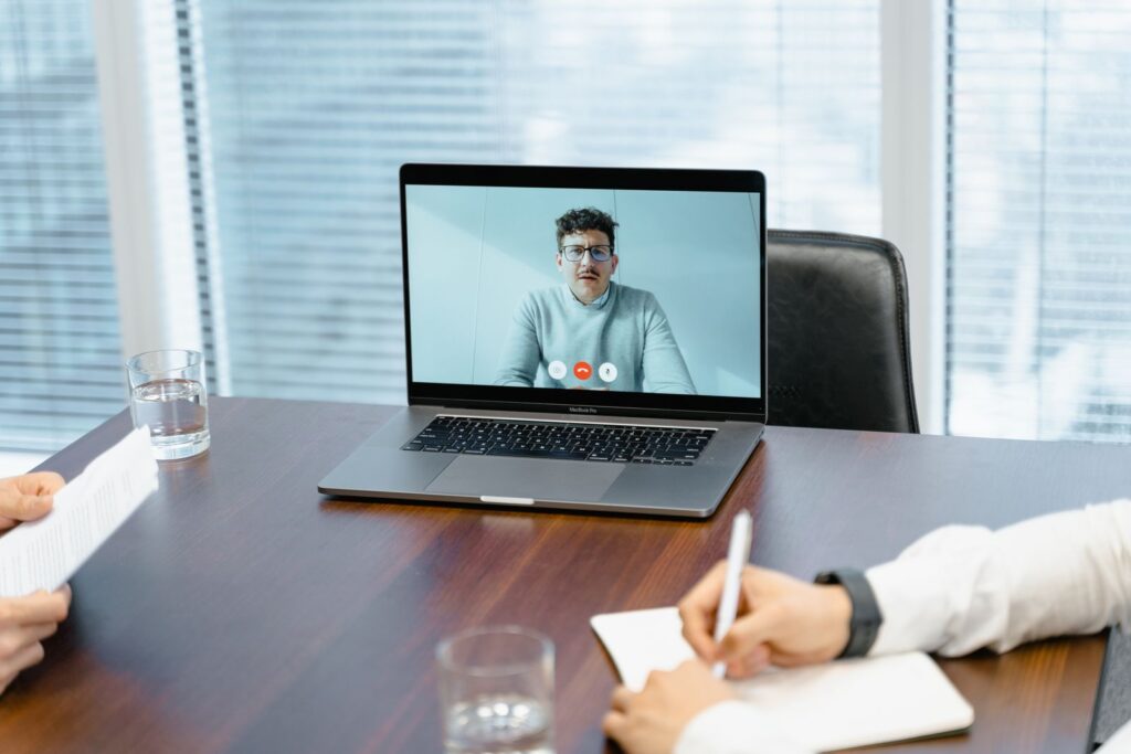 A laptop open on a desk showing a video call
